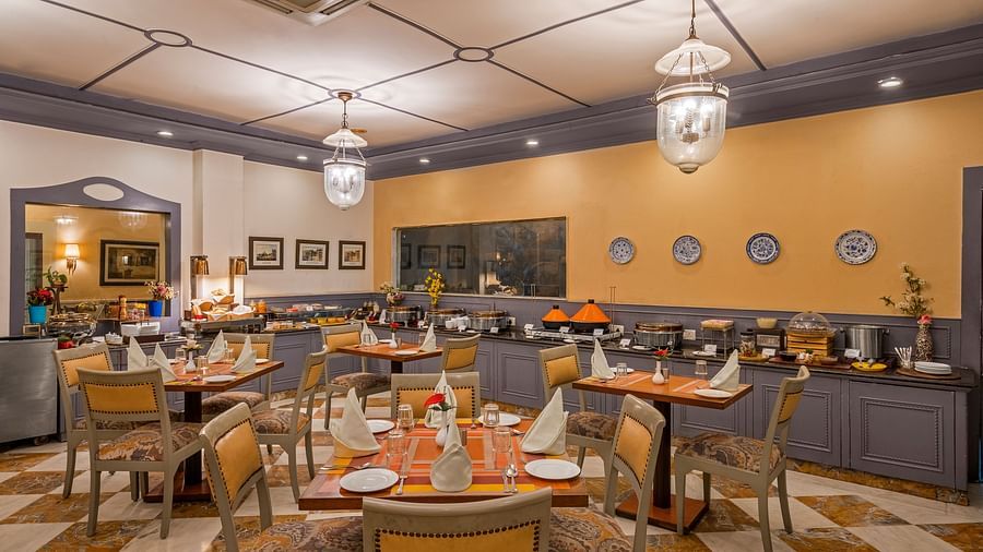 a restaurant with a buffet setting and clusters of tables and chairs - The Manor, Kashipur