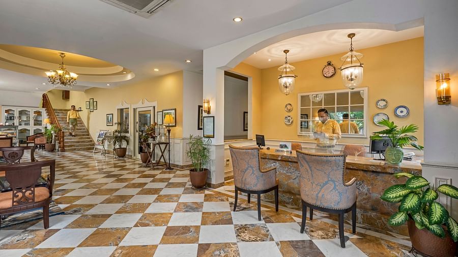 A wide view of the reception of the hotel with chairs and tables in clusters across the room - The Manor, Kashipur