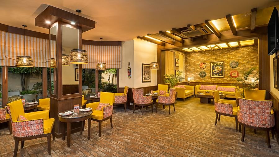 view of a room with clusters of tables and chairs placed close to the walls - The Manor, Kashipur