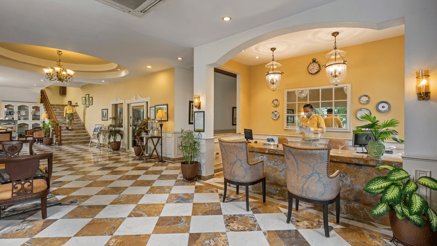 A wide view of the reception of the hotel with chairs and tables in clusters across the room - The Manor, Kashipur