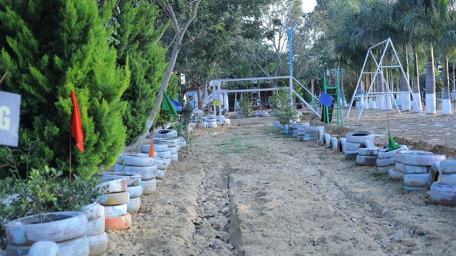 A muddy track lined by tires on both the sides at The Meenakshi Resort by Welcome Inn Hospitality, Bangalore.