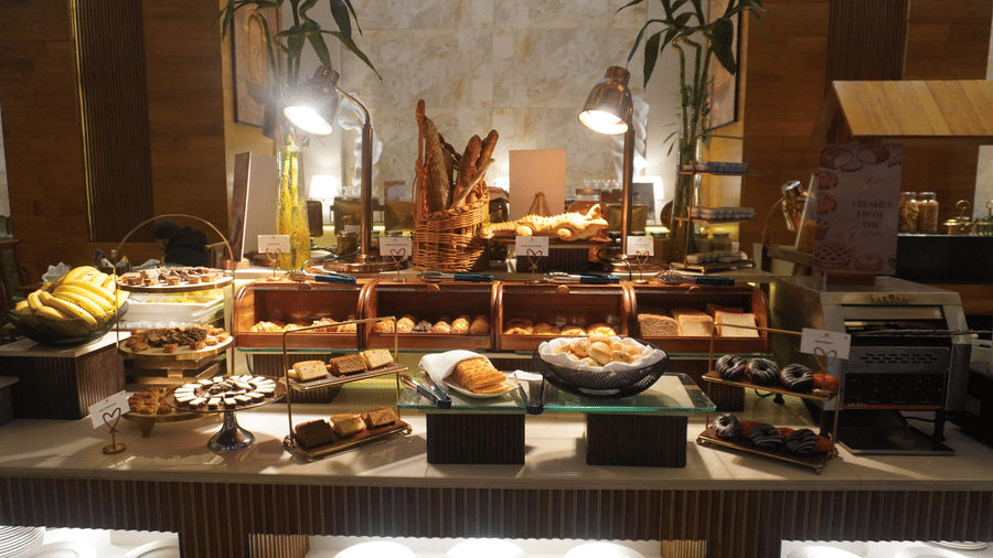 buffet table displaying various fresh fruits and salads in large bowls at the Meriton. 
