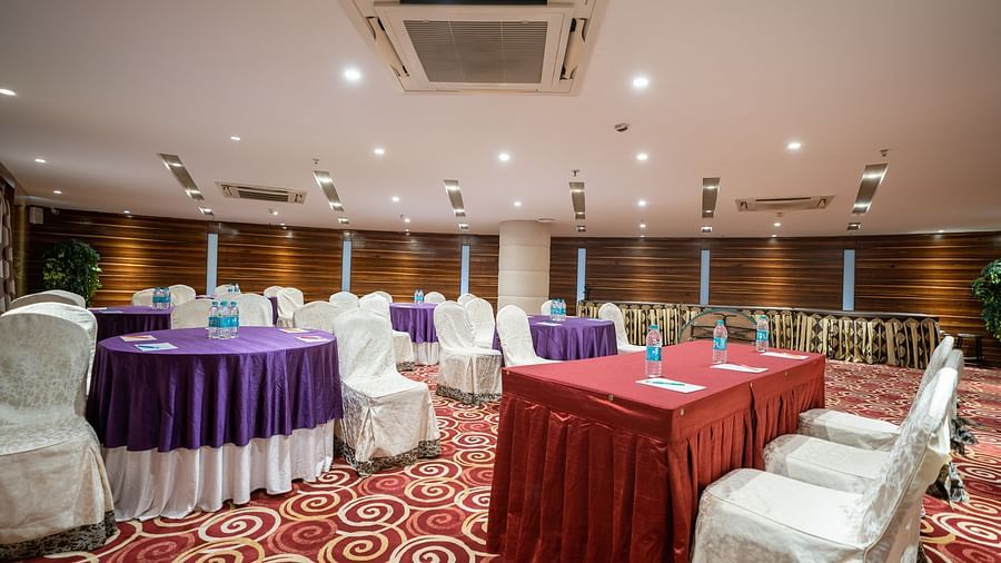 Seating arrangements inside Opal hall with light switched at The President Hotel, Hubli