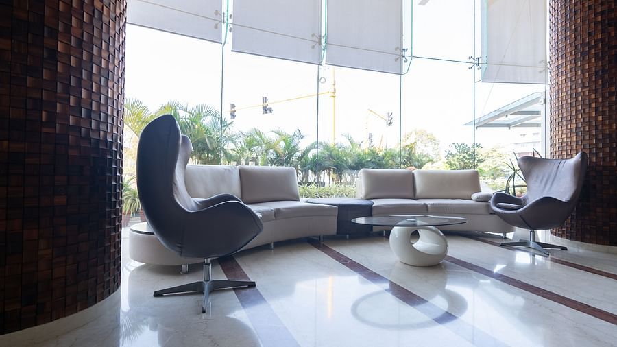 waiting area with a lounge, chairs and a round table at The President Hotel, Hubli