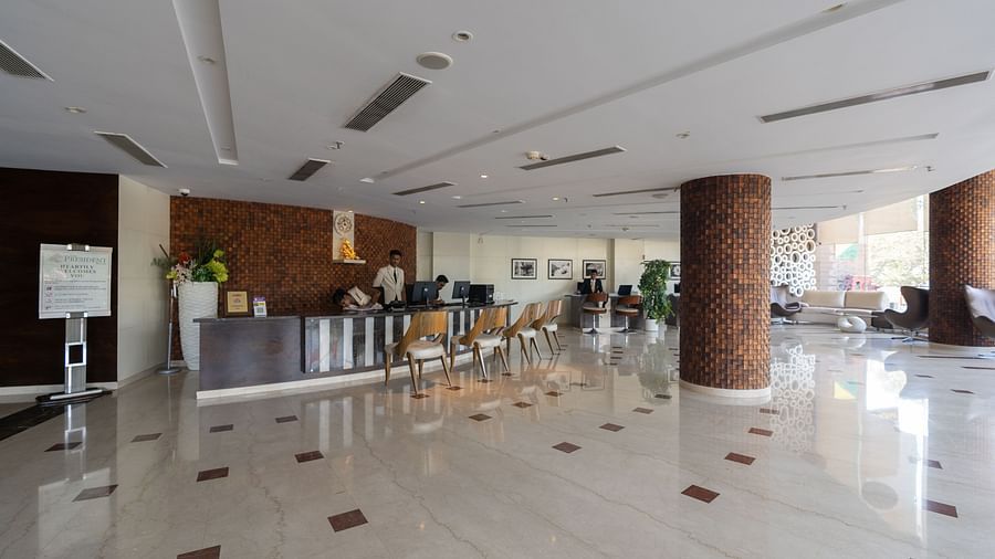 An image showcasing the hotel reception area of The President Hotel, Hubli with people working