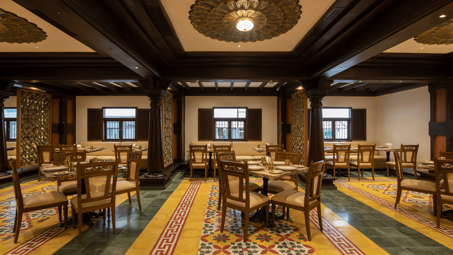 A dining setting at Andhra Ruchulu featuring printed tiles and a wooden-covered ceiling at The President Hotel, Kumara Park, Bangalore