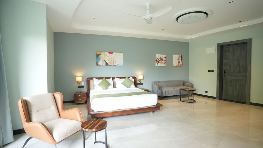 Club Suite with Valley View Sitout including a king size bed, seating area, and minimalist decor at The Qualia Resort Club & Brewery, Udaipur.