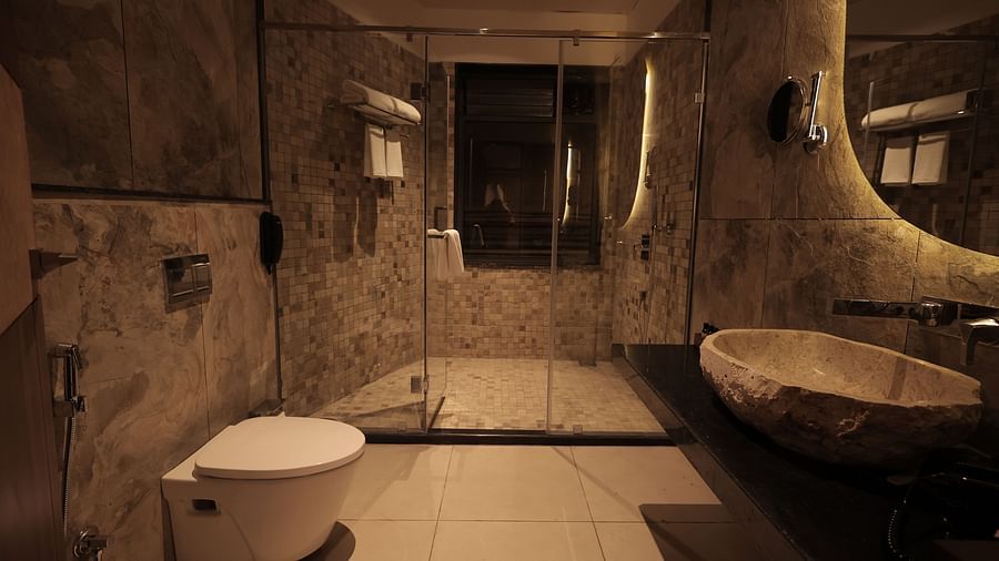A bathroom of Luxury Villa with Plunge Pool showcasing unique fixtures, stone walls, and warm lighting at The Qualia Resort Club & Brewery, Udaipur.