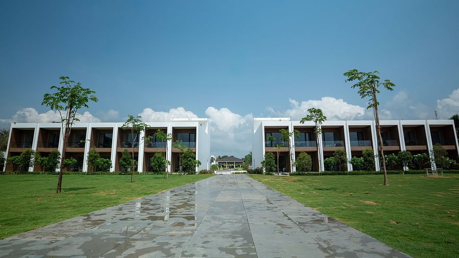 The lawn area at The Shore Trishvam, Pondicherry with a wide concrete pavement going through the middle of it.
