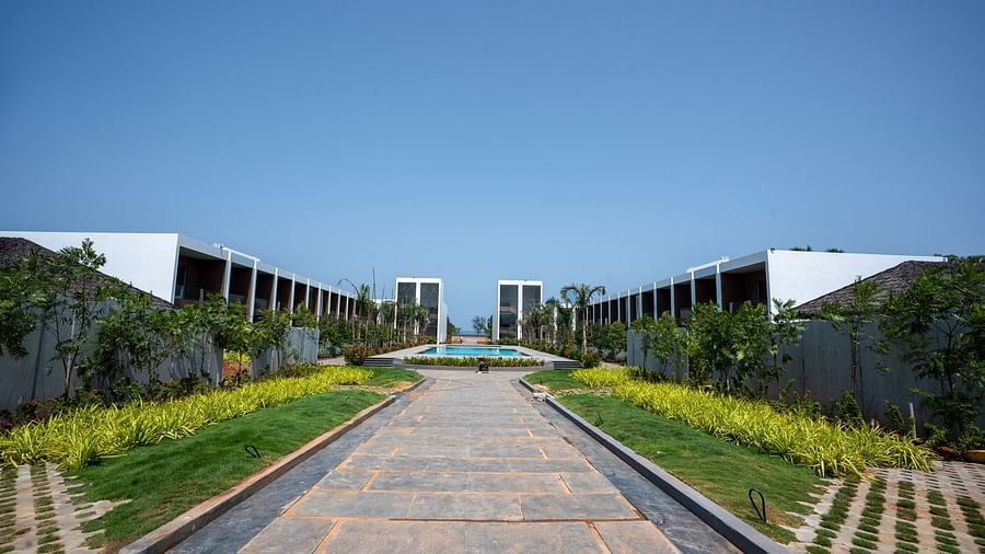 A wide pavement going through the middle of the property at The Shore Trishvam, Pondicherry with a clear blue sky in the background.