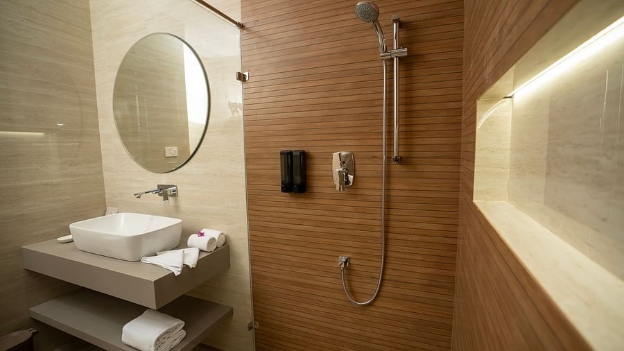 The bathroom of the Exotic Pool Villa with the shower area separated by a glass partition at The Shore, Trishvam.