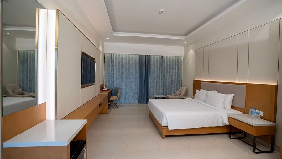 The Garden Courtyard room side angle featuring a a double bed and a wall mounted television right opposite to it at The Shore, Trishvam.