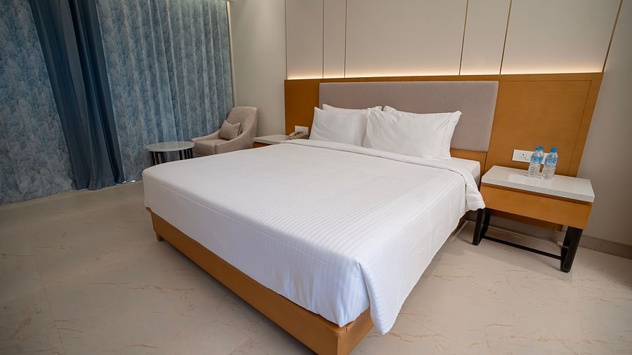 The Garden Courtyard room featuring a double bed neatly tucked with plain white sheets at The Shore, Trishvam.