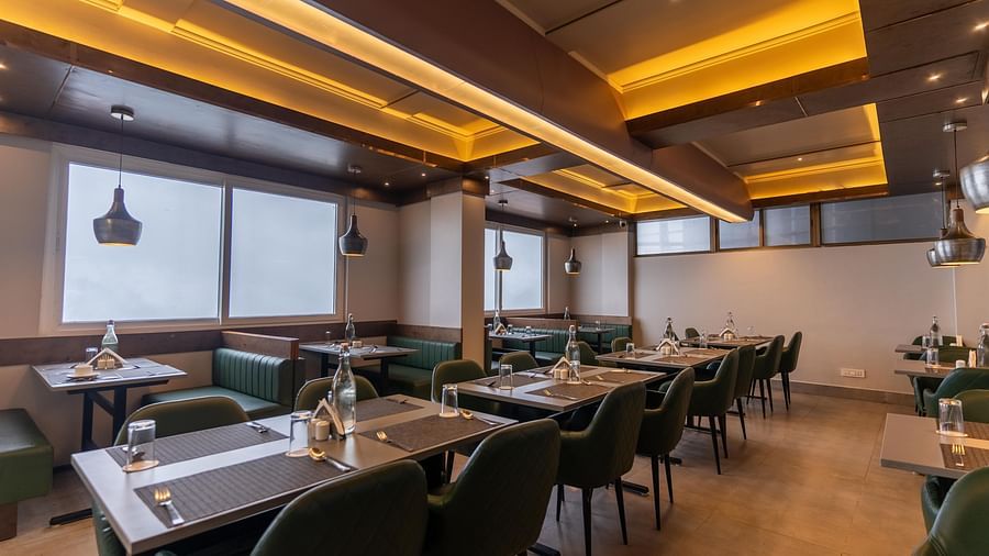 image of the restaurant with large windows at the soma hotel by avianna group, darjeeling