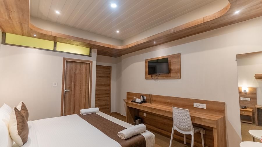 standard room with a work desk and a wall mounted TV at The Soma Hotel by Avianna Group, Darjeeling