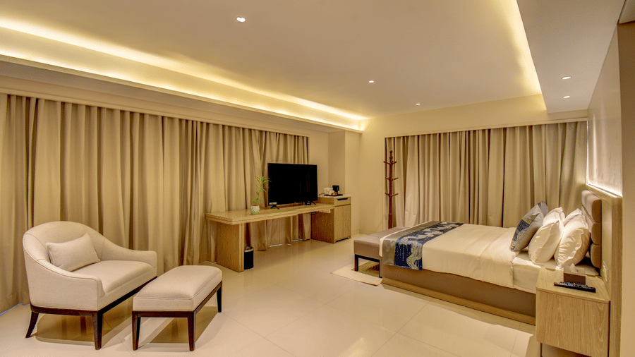 The Deluxe King Room with two beds, a television, and a desk, bright interior lighting - The SSK Solitaire Boutique Hotel & Spa, Gangapur Road - Nashik