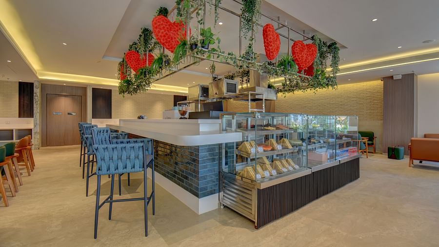 Side view of two sister's cafe The SSK Solitaire Boutique Hotel & Spa, Gangapur Road - Nashik featuring baked goods and chairs.