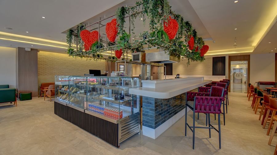 Side view of two sister's cafe The SSK Solitaire Boutique Hotel & Spa, Gangapur Road - Nashik featuring baked goods and chairs.