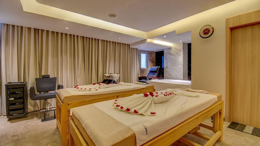Overview of two Spa bed at The SSK Solitaire Boutique Hotel & Spa, Gangapur Road - Nashik featuring a towel in heart shape and flower petals.