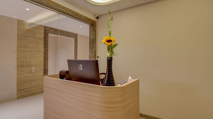 Entrance of spa at The SSK Solitaire Boutique Hotel & Spa, Gangapur Road - Nashik featuring a front desk with flower vase on it.