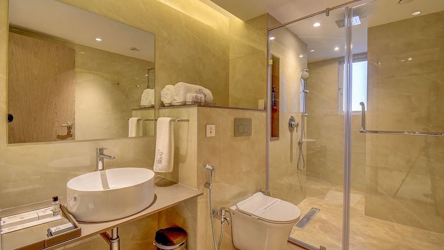 Washroom of a room at The SSK Solitaire Boutique Hotel & Spa, Gangapur Road - Nashik featuring a sink area and a mirror with warm lighting.