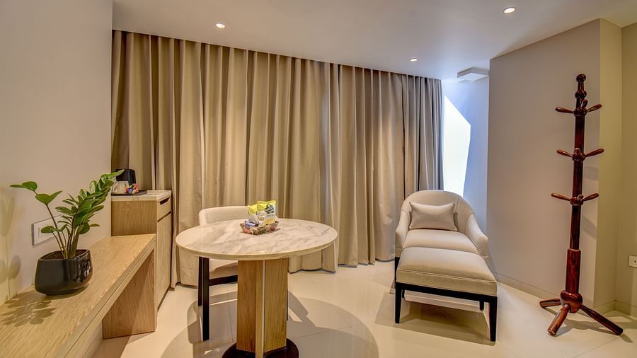 Living area of Deluxe King Room featuring sofa, table, coat hanger and curtains at The SSK Solitaire Boutique Hotel & Spa, Gangapur Road - Nashik