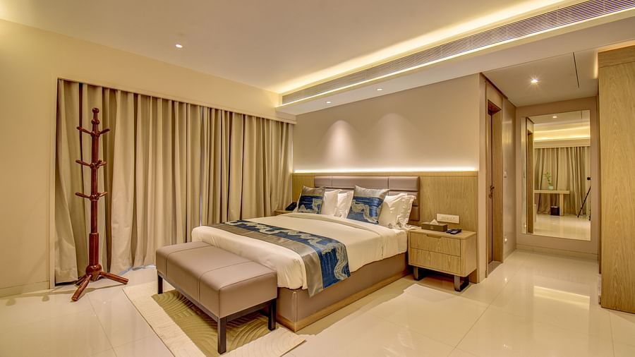 A hotel room with a bed, a bench, and a view of the bathroom - The SSK Solitaire Boutique Hotel & Spa, Gangapur Road - Nashik