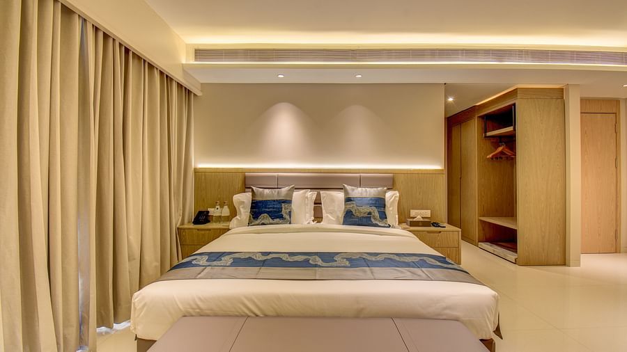 A hotel room with a bed, a closet, and a view of the hallway - The SSK Solitaire Boutique Hotel & Spa, Gangapur Road - Nashik