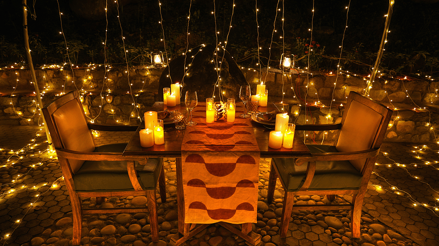 A lavish dining setting surrounded by candle lights at night at Bread and Brook at the Sylvan Retreat, Dehradun.