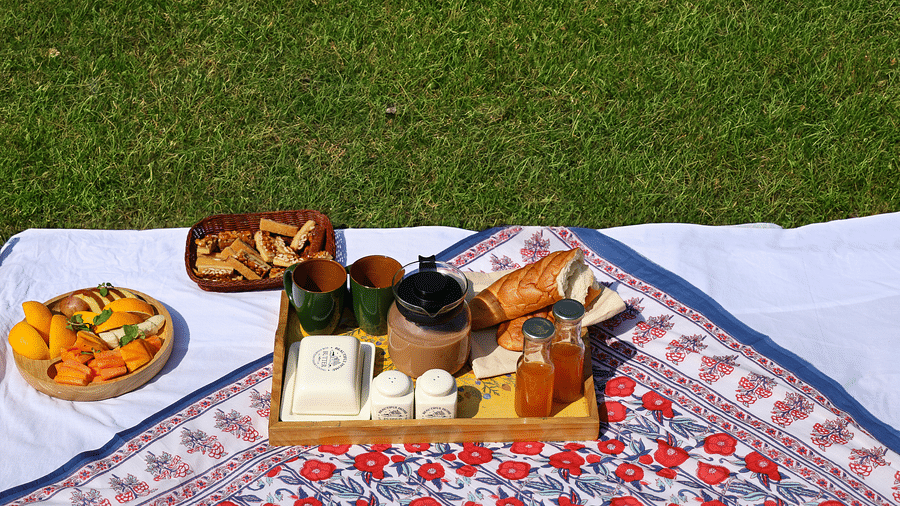 A breakfast platter placed on a cloth on grass at the Sylvan Retreat, Dehradun.