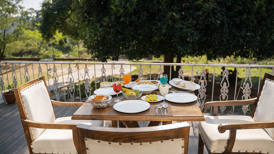 An open dining setting with food served on the table at Bread and Brook at the Sylvan Retreat, Dehradun.