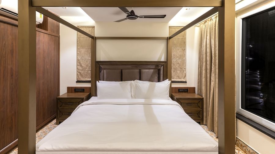 A double bed with wooden beams inside one of the rooms - The Tanisi Hotels & Resorts, Goa