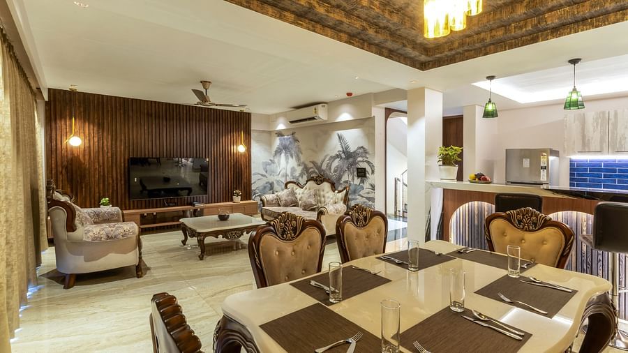 the living room with sofas and a dining table inside one of the rooms - The Tanisi Hotels & Resorts, Goa