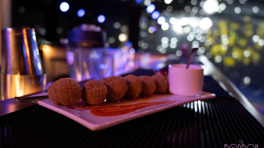 image of a plate with snacks served with a dip at the bourbon club and lounge - The Tattva Boutique Resort