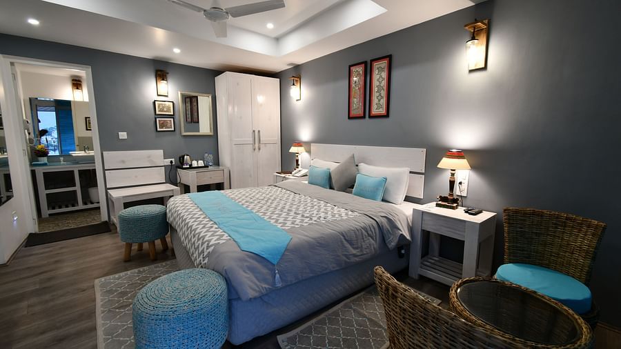 image of a dimly lit premium room with a double bed in the middle along with a white coloured wardrobe in the corner - The Tattva Boutique Resort