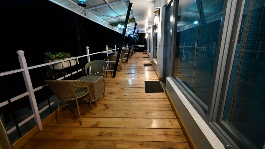 full view image of the balcony in the premium room with wooden flooring during the night - The Tattva Boutique Resort