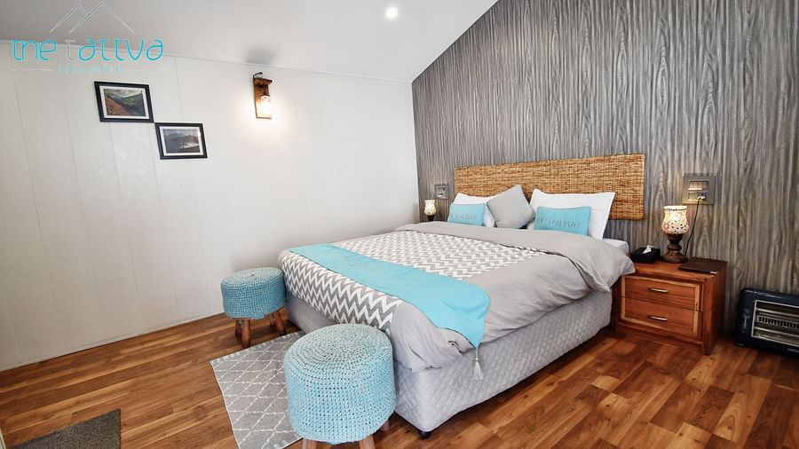 corner view image of the deluxe room with a grey coloured master wall behind the bed - The Tattva Boutique Resort