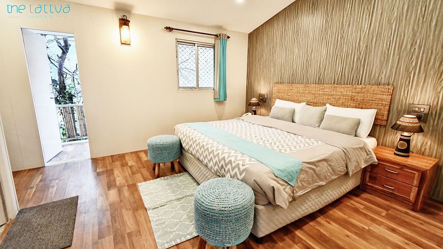full view image of the deluxe room with a plush double bed with warm lighting in the room - The Tattva Boutique Resort