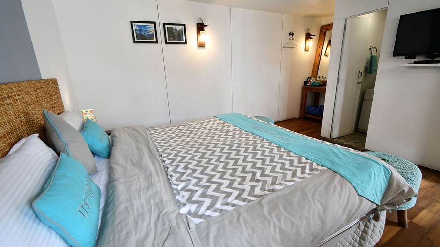 close up image of the double bed in the deluxe room with a soft comforter spread over it - The Tattva Boutique Resort