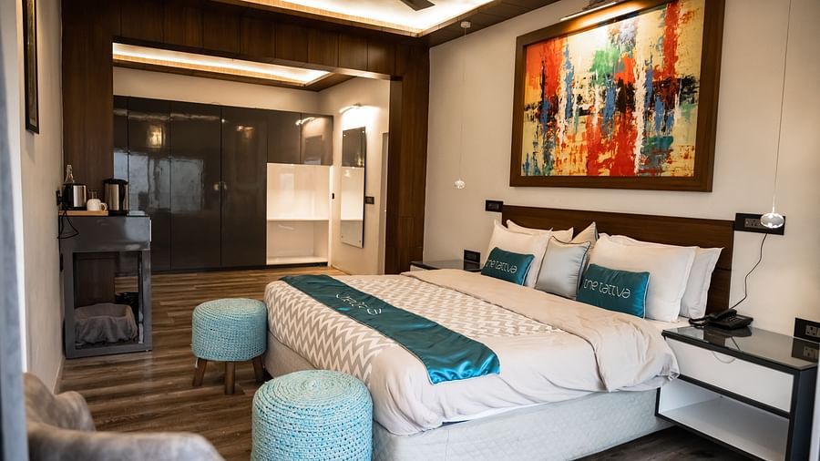 coner view image of the bedroom featuring a comfortable double bed with ample natural light at the pent house - The Tattva Boutique Resort