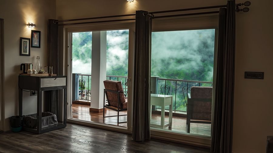 image of the balcony separated with huge french windows in the pent house with beutiful lush green views - The Tattva Boutique Resort