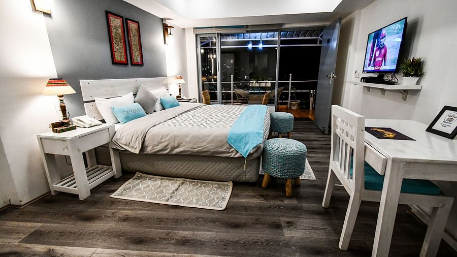 side view image of the premium room featuring a double bed and a wall mounted tv placed opposite to it - The Tattva Boutique Resort