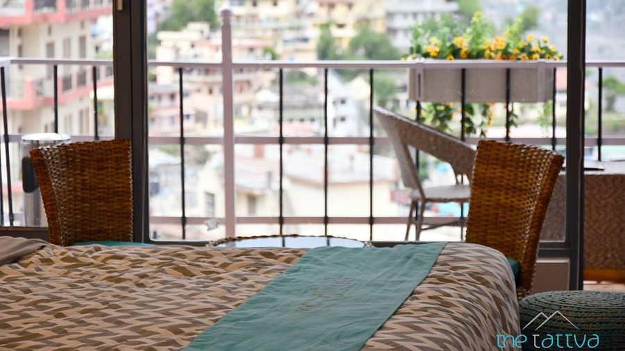 close up image of the bed in the premium room over looking the views from the balcony - The Tattva Boutique Resort