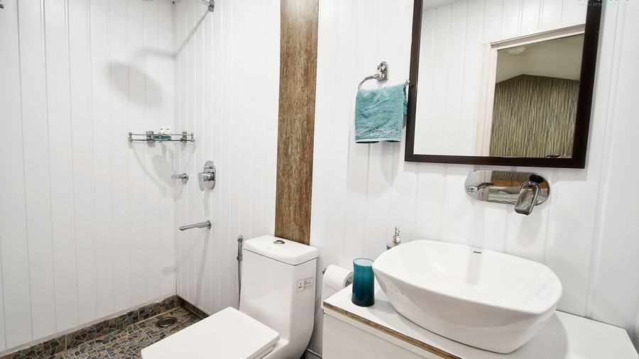 image of the bathroom of the standard room featuring a small wash area along with a commode - The Tattva Boutique Resort