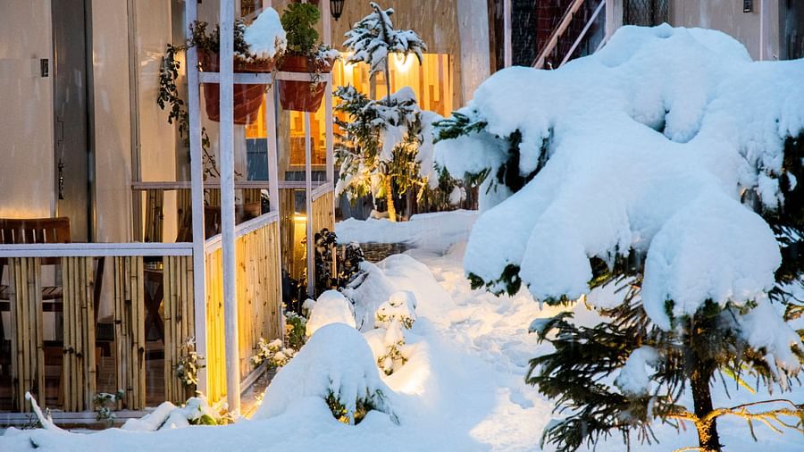 close up image of the porch of a villa with snow surrounding it from all corners