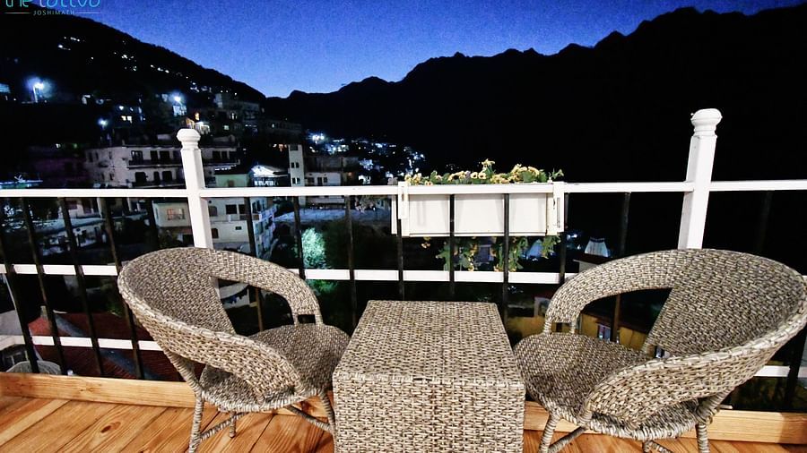 image of a two chairs kept opposite to each other with a beautiful city views on a late evening at the tattva, joshimath