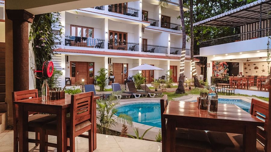 An inviting poolside dining area with wooden tables – The Verda de Miranda Resort.