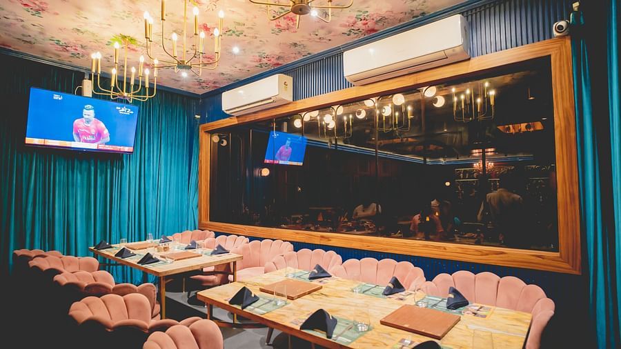 An image of a restaurant with sofa chairs, tables, air conditioners, TV screens, chandelier lights at Themis Barbecue House, NSP Pitampura