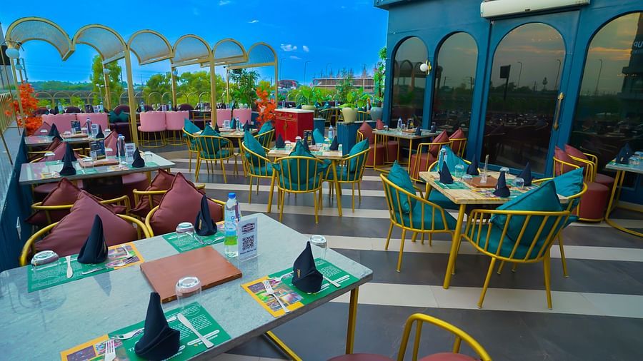 An image of restaurant with several sets of tables and chairs placed everywhere - Themis Barbecue House, NSP Pitampura