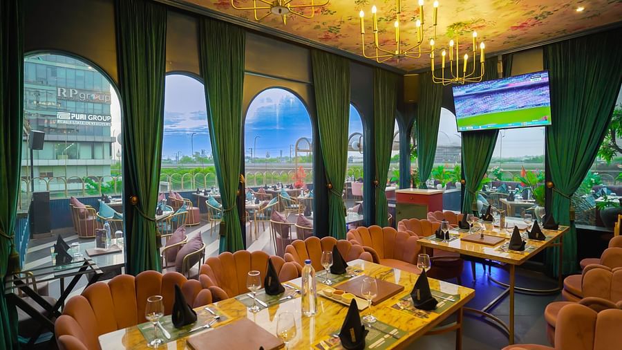 An image of a beautifully decorated with sofa chairs, tables, and windows styled with curtains - Themis Barbecue House, NSP Pitampura